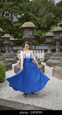 Schöne hispanische Frau mit Brille, die sich fröhlich in ihrem Kleid dreht, um den Tempel des ueno Parks in tokio. Ihr lebendiger Geist tanzt im urbanen Settin Stockfoto