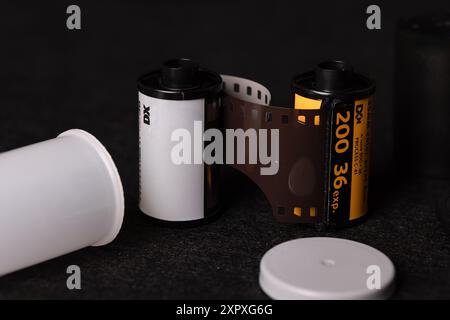 Detaillierte Ansicht von 35-mm-Filmrollen vor dunklem Hintergrund, die das Wesen der analogen Fotografie mit einem zeitlosen Gefühl festhalten. Stockfoto