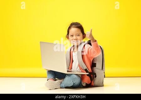 Enthusiastisches koreanisches Kind, das den Daumen nach oben zeigt, lebt im Online-Lernen. Entzückendes japanisches Kind brilliert im digitalen Klassenzimmer Stockfoto