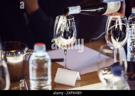 Person, Die Wein In Weinglas Gießt Stockfoto
