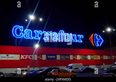 Bukarest, Rumänien - 23. Mai 2024: Carrefour Hypermarket-Logo und mehrere Logos für Einzelhandel und Restaurants an der Seitenfassade des Orhideea Einkaufszentrums in n Stockfoto