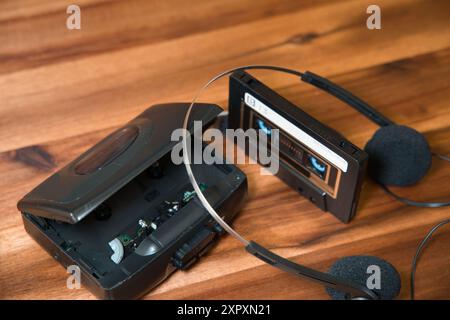 Alter walkman ® mit Kassette und Kopfhörern auf einem Holztisch. Retro Stockfoto