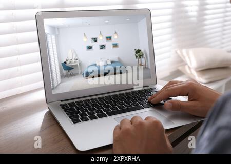 Mann sucht Haus auf der Immobilienmarkt-Website am Tisch, Nahaufnahme Stockfoto