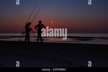 Angler am Nordseestrand bei Sonnenuntergang, Niederlande, Südholland, Katwijk Stockfoto