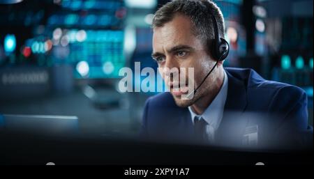Porträt eines Finanzanalysten mit einem Desktop-Computer mit Echtzeit-Diagrammen, Finanzberichten und Marktaktualisierungen. Händler, der an einer modernen Börse arbeitet und mit Brokern kommuniziert Stockfoto
