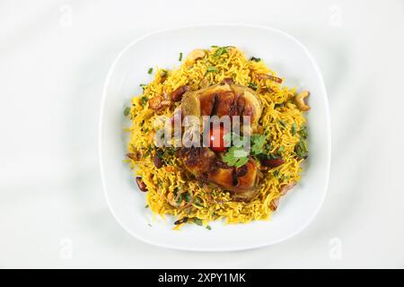 Arabische Küche; Hühnchen 'Kabsa' oder Hühnchen Biryani Reis. Serviert mit goldgebratenen Zwiebeln, knusprigen gerösteten Nüssen und Rosinen, frischer Petersilie, Stockfoto