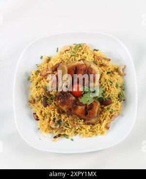 Arabische Küche; Hühnchen 'Kabsa' oder Hühnchen Biryani Reis. Serviert mit goldgebratenen Zwiebeln, knusprigen gerösteten Nüssen und Rosinen, frischer Petersilie, Stockfoto