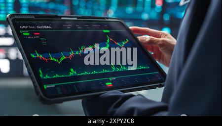 Nahaufnahme eines Tablet-Computer-Monitors mit Echtzeitbeständen, Rohstoffen, Börsenmärkten mit Tickern in einem Finanzbüro Stockfoto