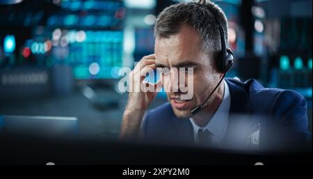 Porträt eines Finanzanalysten mit einem Desktop-Computer mit Echtzeit-Diagrammen, Finanzberichten und Marktaktualisierungen. Händler, der an einer modernen Börse arbeitet und mit Brokern kommuniziert Stockfoto