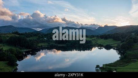 Panoramablick aus der Vogelperspektive auf den Loughrigg tarn in der Nähe des Skelwith Bridge Lake District bei Sonnenuntergang mit den langdale Pikes jenseits von niemandem Stockfoto