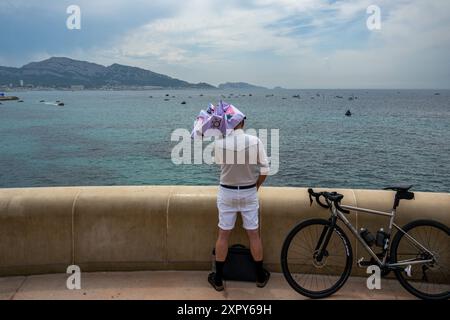 Marseille, Frankreich. August 2024. Ein Zuschauer beobachtet von der Corniche Kennedy den Start des gemischten Jollenrennens auf der Wasseroberfläche der Olympischen Marina in Marseille, Frankreich am 07. August 2024. Foto: Laurent Coust/ABACAPRESS. COM Credit: Abaca Press/Alamy Live News Stockfoto