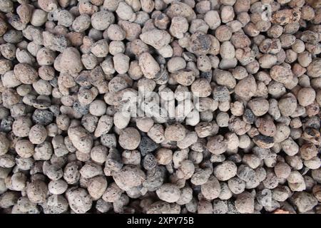 Schotternahmehilfe. Steinkiesel aus nächster Nähe. Natürlicher Gebäudehintergrund. Stockfoto