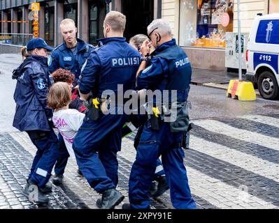 Polizei zwangsweise die Teilnehmer einer Demonstration der Niittykukka-Kampagne für Bestäuber und gegen den Rückgang der Bestäuber in Helsinki. Stockfoto