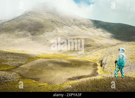 Wanderer-Trekking-Stand aus der Vogelperspektive am Aussichtspunkt in Georgien besuchen Sie den speziellen alpinen Sakori-See hoch in den kaukasus-Bergen in Georgien. Nebelsee Stockfoto