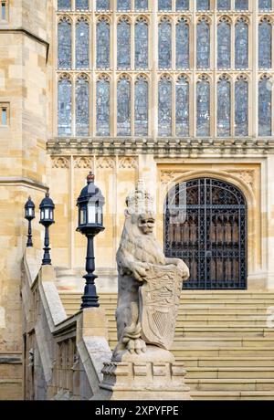 Steinlöwe mit einem Schild mit den königlichen Wappen, auf den Stufen des Westeingangs zur St George Chapel, Windsor Castle, Windsor, Berkshire, England Stockfoto