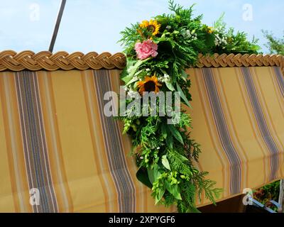 Blumenkranz mit Sommerblüten auf einem Liegestuhl, perfekt für Karten und Sommergrüße. Ein bezauberndes Geschenk für eine Sommerfeier. Stockfoto