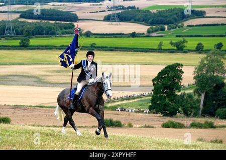 Coldstream, Großbritannien. August 2024. Coldstream Civic Week - Flodden Rideout als Teil der Coldstream Civic Week der jährliche Ritt zum Schauplatz der Schlacht von Flodden (9. September 1513) auf Branxton Hill trägt der Coldstreamer Mr. Jake Kerr den Stadtstandard und galoppiert am Ort der Schlacht auf Branxton Hill. es folgten fast 200 Anhänger. (Quelle: Rob Gray/Alamy Live News Stockfoto