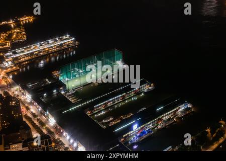 Luftblick mit privaten Docks mit Luxusbooten und Yachten. Panorama der Gegend von einem Hubschrauber aus mit Wohn- und Industriegebäuden. Hafenbereich mit Schiff und Ladeausrüstung Stockfoto