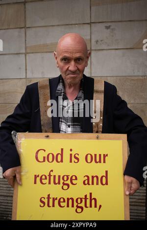 Mann mit Sandwichbrett und Botschaft Gott ist unsere Zuflucht und Stärke. Busbahnhof Piccadilly Gardens, Manchester UK Stockfoto