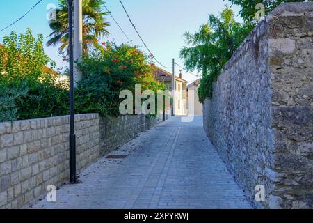 Nin, Kroatien, 24. Juli 2024: Kopfsteinpflasterplatz und alte Straße mit Steinbrunnen in der historischen Stadt Nin in Dalmatien. Stockfoto