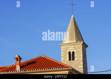 Nin, Kroatien, 24. Juli 2024: Der historische Glockenturm der Kirche St. Anselm erhebt sich vor einem klaren blauen Himmel in Nin. Stockfoto