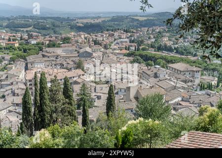 Luftbild mit Ziegeldächern und Blick auf die historische Kleinstadt auf einem Hügel, aufgenommen im hellen Sommerlicht in Amelia, Umbrien, Italien Stockfoto