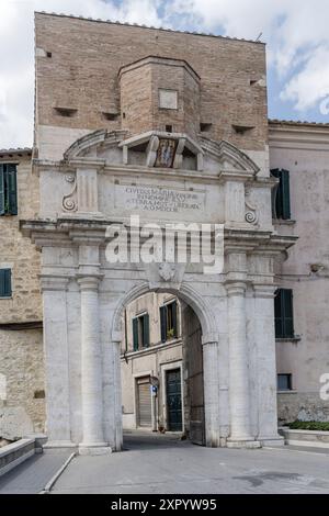 Stadtlandschaft mit historischem Porta Romana monumentalem Eingang an den Stadtmauern, aufgenommen in hellem Sommerlicht in Amelia, Umbrien, Italien Stockfoto