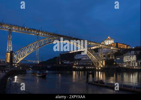 Nachtansicht auf Porto mit Dom Luis I Brücke, Duoro Fluss und Mosteiro da Serra do Pilar mit Reflexion im Wasser Stockfoto