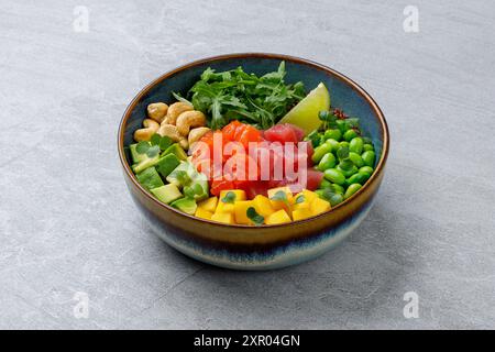 Poke Bowl mit Lachs und Thunfisch auf grauem Hintergrund Stockfoto