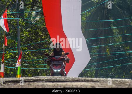 8. August 2024, West Bandung Regency, West Java, Indonesien: Ein Motorradpass unter einem 240 Meter langen rot-weißen Tuch, um den 79. Jahrestag der Unabhängigkeit der Republik Indonesien im Pasirpogor Village, West Bandung Regency, West Java, zu begrüßen. (Kreditbild: © Dimas Rachmatsyah/ZUMA Press Wire) NUR REDAKTIONELLE VERWENDUNG! Nicht für kommerzielle ZWECKE! Stockfoto