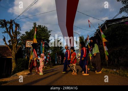 8. August 2024, West Bandung Regency, West Java, Indonesien: Kinder überqueren die Straße unter einem 240 Meter langen rot-weißen Tuch, um den 79. Jahrestag der Unabhängigkeit der Republik Indonesien im Pasirpogor Village, West Bandung Regency, West Java, zu begrüßen. (Kreditbild: © Dimas Rachmatsyah/ZUMA Press Wire) NUR REDAKTIONELLE VERWENDUNG! Nicht für kommerzielle ZWECKE! Stockfoto