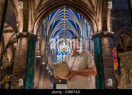 Bildhauer Ewan Allinson mit einer seiner Sandsteinskulpturen in der Kunstausstellung zum 900. Geburtstag der St Giles Cathedral in Edinburgh, Schottland, Großbritannien Stockfoto