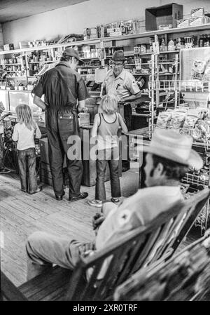 Mazedonien, Arkansas, USA – 23. Juni 2024: Vertikale Aufnahme einer Familie, die 1975 in einem alten Arkansas-Laden Einkäufe tätigt. Stockfoto