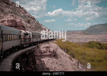 Clarkdale, Arizona, USA - 16. Mai 2024: Touristenzug durchquert das Verde-Tal mit Schönwetterwolken am blauen Himmel Stockfoto