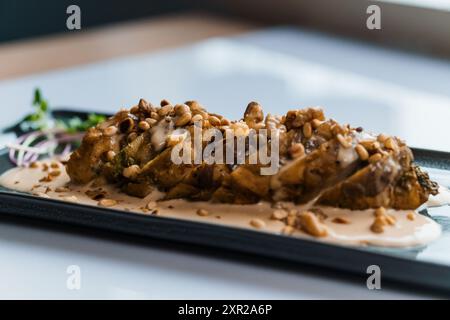 Gedünstetes Fleisch in Pilzsauce und Kräutern auf einer Keramikplatte Stockfoto