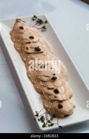 Gedünstetes Fleisch in Pilzsauce und Kräutern auf einer Keramikplatte Stockfoto