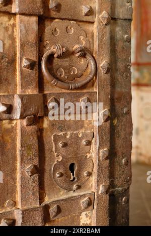 Fragment einer antiken Metalltür mit Schloss und rundem Griff. Teil einer alten Eisentürnähe. Stockfoto