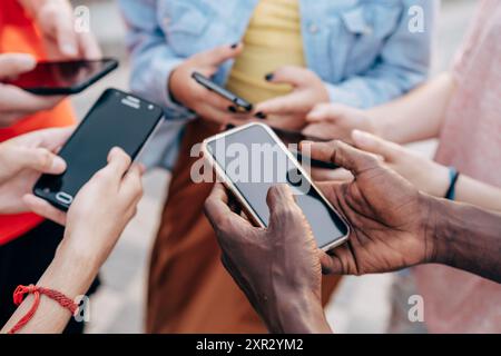 Nahaufnahme von jungen multikraziellen Menschen, die Smartphones nutzen – Details zu Freunden, die Fotos über soziale Netzwerke mit Smartphone teilen – Technologie Concep Stockfoto