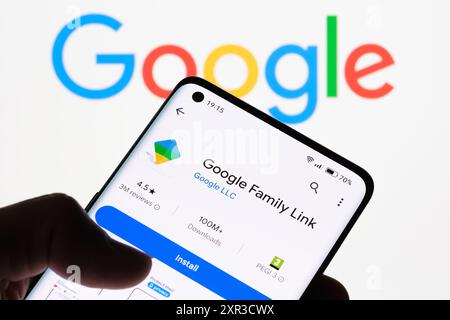 Nahaufnahme eines Smartphone-Bildschirms, auf dem die Google Family Link-App mit dem Google-Logo im Hintergrund angezeigt wird, wodurch die Verbindung zwischen Google Famil hervorgehoben wird Stockfoto