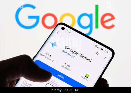 Nahaufnahme eines Smartphone-Bildschirms, auf dem die Google Gemini-App mit dem Google-Logo im Hintergrund angezeigt wird und der Link zwischen Google Gemini und Google, St Stockfoto
