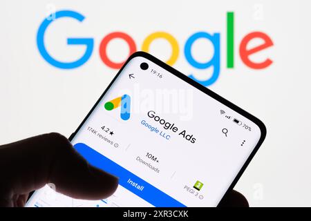 Nahaufnahme eines Smartphone-Bildschirms, auf dem die Google Ads-App mit dem Google-Logo im Hintergrund angezeigt wird, um die Verbindung zwischen Google Ads und Googl zu veranschaulichen Stockfoto