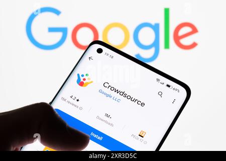 Nahaufnahme eines Smartphone-Bildschirms, auf dem die Crowdsource-App mit Google-Logo im Hintergrund angezeigt wird, um die Verbindung zwischen Crowdsource und Goo zu veranschaulichen Stockfoto