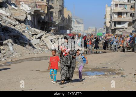 Gaza. August 2024. Am 8. August 2024 fliehen Menschen aus den östlichen Bezirken der Stadt Khan Younis im südlichen Gazastreifen. Nach einer neuen Evakuierungsanordnung der israelischen Behörden sagten UN-humanitäre Helfer am Donnerstag, dass ihre Partner Tausende von Gazern erneut aus Teilen des Gebiets Khan Younis im Westen in Richtung Al Mawasi flohen. Quelle: Rizek Abdeljawad/Xinhua/Alamy Live News Stockfoto