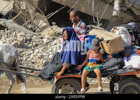 Gaza. August 2024. Am 8. August 2024 fliehen Menschen aus den östlichen Bezirken der Stadt Khan Younis im südlichen Gazastreifen. Nach einer neuen Evakuierungsanordnung der israelischen Behörden sagten UN-humanitäre Helfer am Donnerstag, dass ihre Partner Tausende von Gazern erneut aus Teilen des Gebiets Khan Younis im Westen in Richtung Al Mawasi flohen. Quelle: Rizek Abdeljawad/Xinhua/Alamy Live News Stockfoto