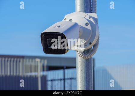 Weiße Überwachungskamera auf der Straße, Sicherheitsdienst in der Stadt. Verdeckte Aufzeichnung dessen, was passiert. Moderne Technologie und Ausstattung. Stockfoto