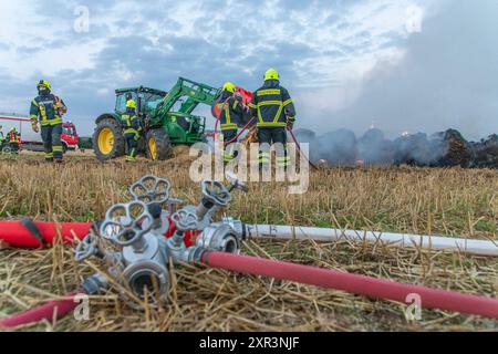 240808Strohballenbrand News ID: EN 2024-08-08-08, Strohballenbrand beschäftigt Einsatzkräfte Landwirte unterstützen Brandbekämpfung Gornau. Am Donnerstagabend gegen 19:50 Uhr ist auf einem Feld an der Eisenstraße ein Strohballenbrand ausgebrochen. Wie die Feuerwehr berichtet, standen bei Ankunft der ersten Kräfte, 30 Strohballen in Vollbrand. Umgehend begann man mit der Brandbekämpfung. Zeitgleich verhinderten die Kameraden eine weitere Ausbreitung des Brandes. Unterstützt werden die Löschmaßnahmen von Landwirten. Diese pflügten das Stoppelfeld um und nahmen so dem Feuer das brennbare Material. Au Stockfoto