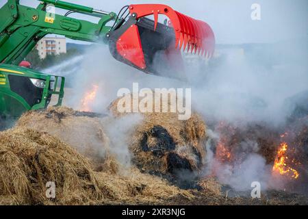 240808Strohballenbrand News ID: EN 2024-08-08-08, Strohballenbrand beschäftigt Einsatzkräfte Landwirte unterstützen Brandbekämpfung Gornau. Am Donnerstagabend gegen 19:50 Uhr ist auf einem Feld an der Eisenstraße ein Strohballenbrand ausgebrochen. Wie die Feuerwehr berichtet, standen bei Ankunft der ersten Kräfte, 30 Strohballen in Vollbrand. Umgehend begann man mit der Brandbekämpfung. Zeitgleich verhinderten die Kameraden eine weitere Ausbreitung des Brandes. Unterstützt werden die Löschmaßnahmen von Landwirten. Diese pflügten das Stoppelfeld um und nahmen so dem Feuer das brennbare Material. Au Stockfoto