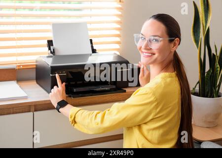 Geschäftsfrau, die Drucker im Büro benutzt Stockfoto