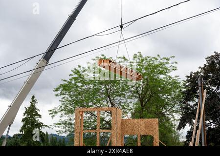 Wohnhausbau, Auslegerkran, Holzlieferungen, Stützträgerbalken, bis zur nächsten Etage des Projekts Stockfoto