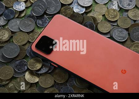 Terengganu, Malaysia - 24. August 2024 : Nahaufnahme des orangen google Pixel 4 Smartphones auf verstreuten malaysischen Münzen Stockfoto